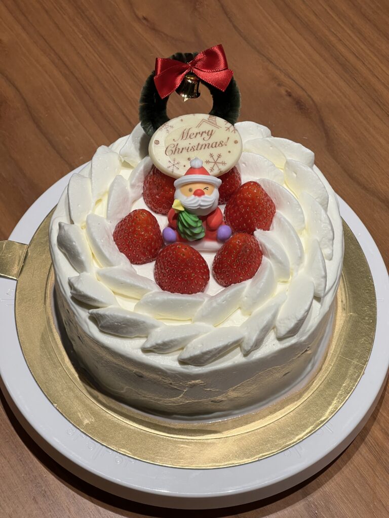 A strawberry shortcake that is Christmas themed with a little Santa in the middle.