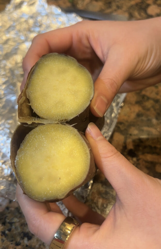 A photo of a baked Japanese sweet potato cut in half and it reveals a silky sweet Japanese sweet potato.